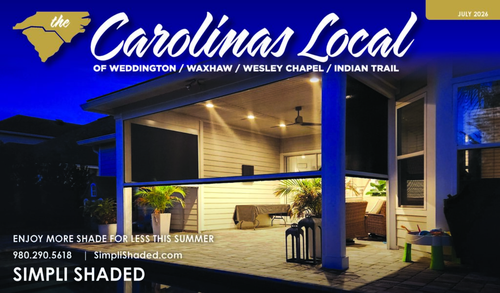 A covered patio with outdoor furniture and lights is shown at night. The image promotes Simpli Shaded, a trusted sunpro dealer offering shade solutions, featured in the July 2026 Carolina Local magazine. Contact info and website are visible.